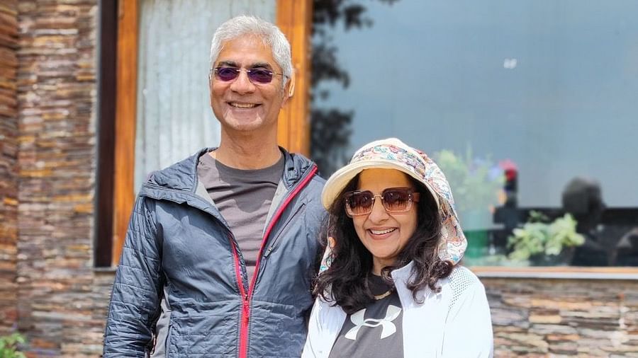 Man and woman standing and smiling in front of a glass-windowed building at the resort.