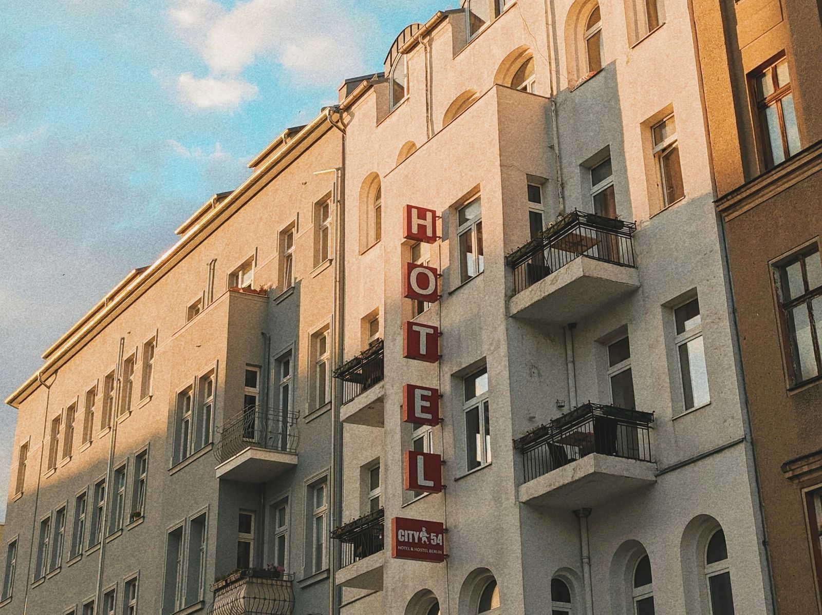  A low-angle view of a row of European-style buildings with balconies under a blue sky