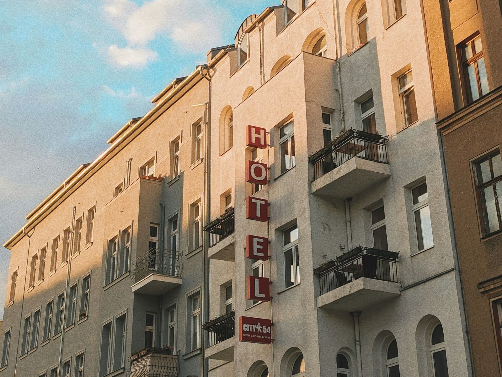  A low-angle view of a row of European-style buildings with balconies under a blue sky