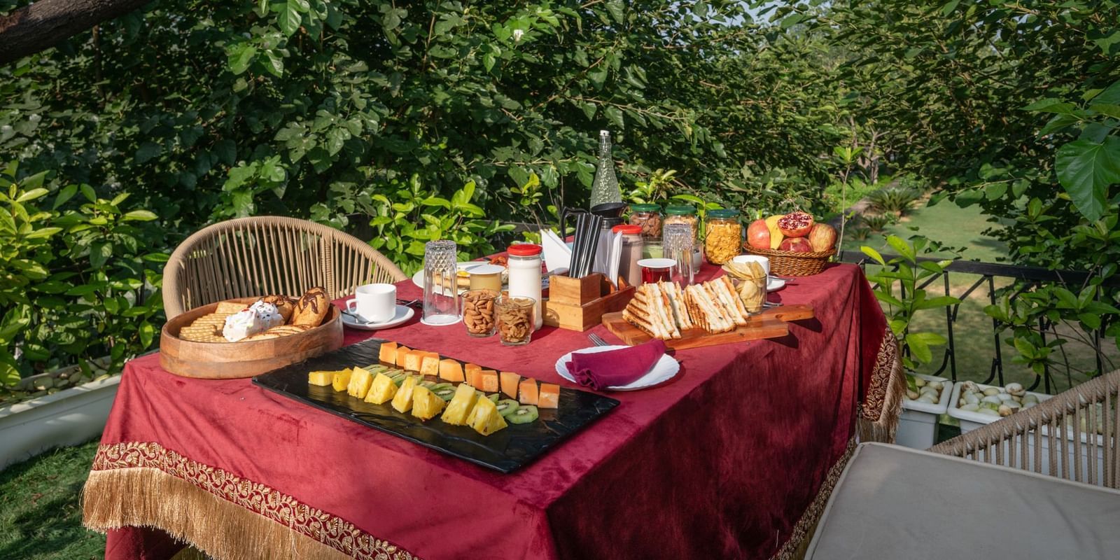 A table filled with food set in an outdoor space surrounded by lush plants at Valley by Grassfield.