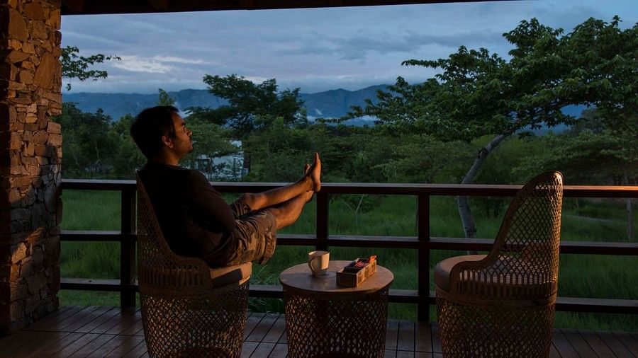 person enjoying the sunset from the balcony of one of the rooms at The Serai Bandipur