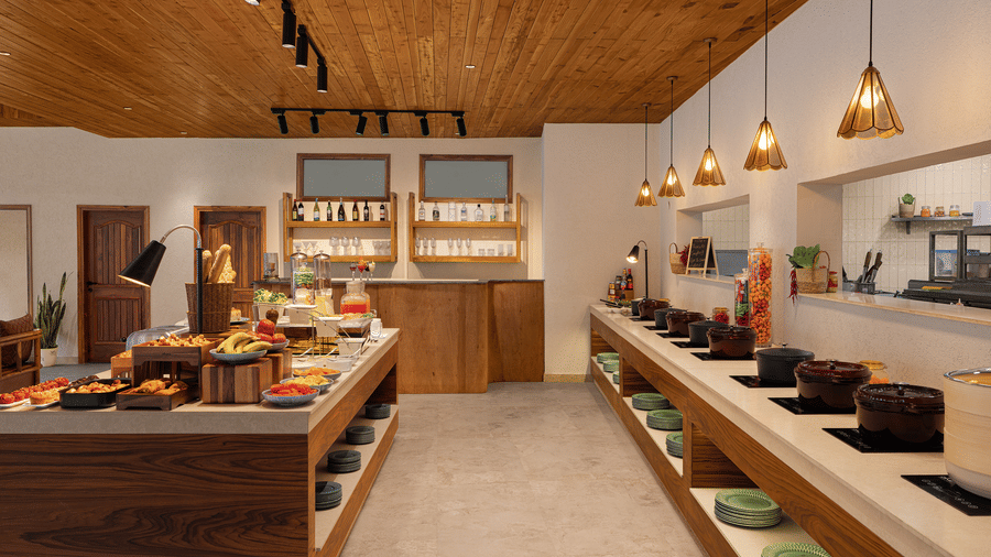 Modern resort restaurant buffet and food service counter with warm lighting and wooden ceiling.