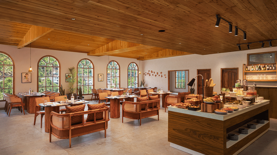Spacious resort dining room with arched windows, elegant wooden tables, chairs, and buffet counter.