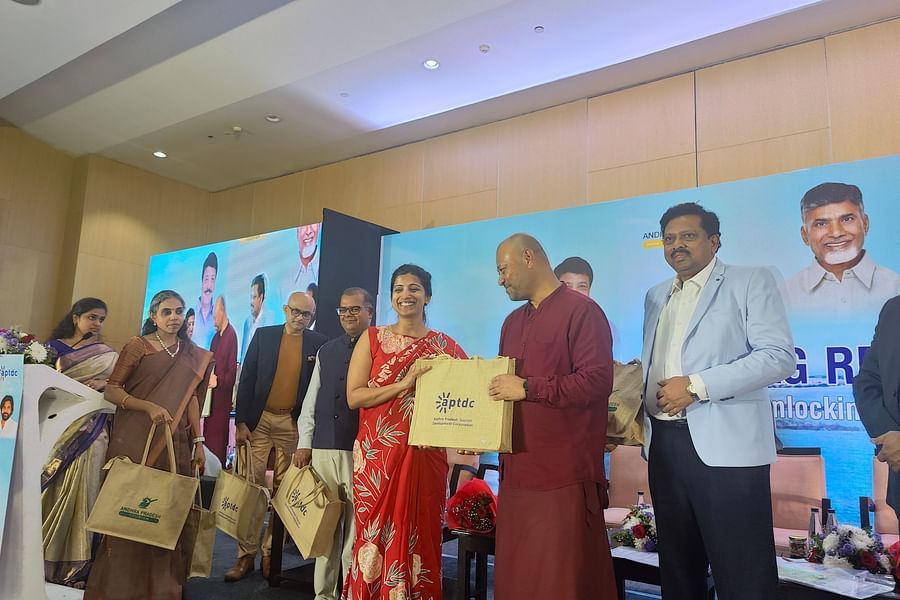 Dignitaries at the Vizag Regional Investors Meet exchange eco-friendly gift bags, marking the event with smiles and camaraderie.