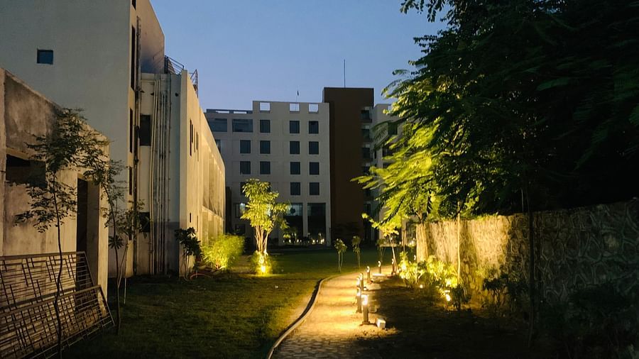 A front night view of the facade of Pride Resort Ambaji with some trees in the picture around it