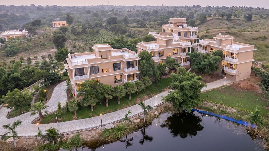 An aerial image of our building with the reflection of the trees surrounding it in the nearby water body - Rajbagh Wellness, Udaipur