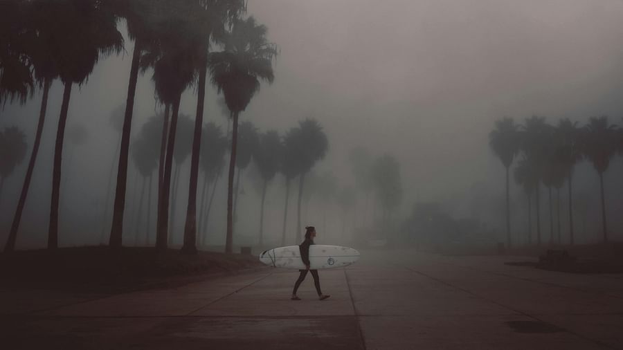 man walking with surfboard