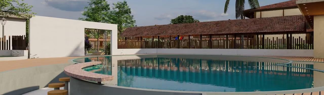 A resort with a pool area, including steps leading into the water and surrounding buildings, under a partly cloudy sky.| Ayana Resorts & Convention, Hyderabad