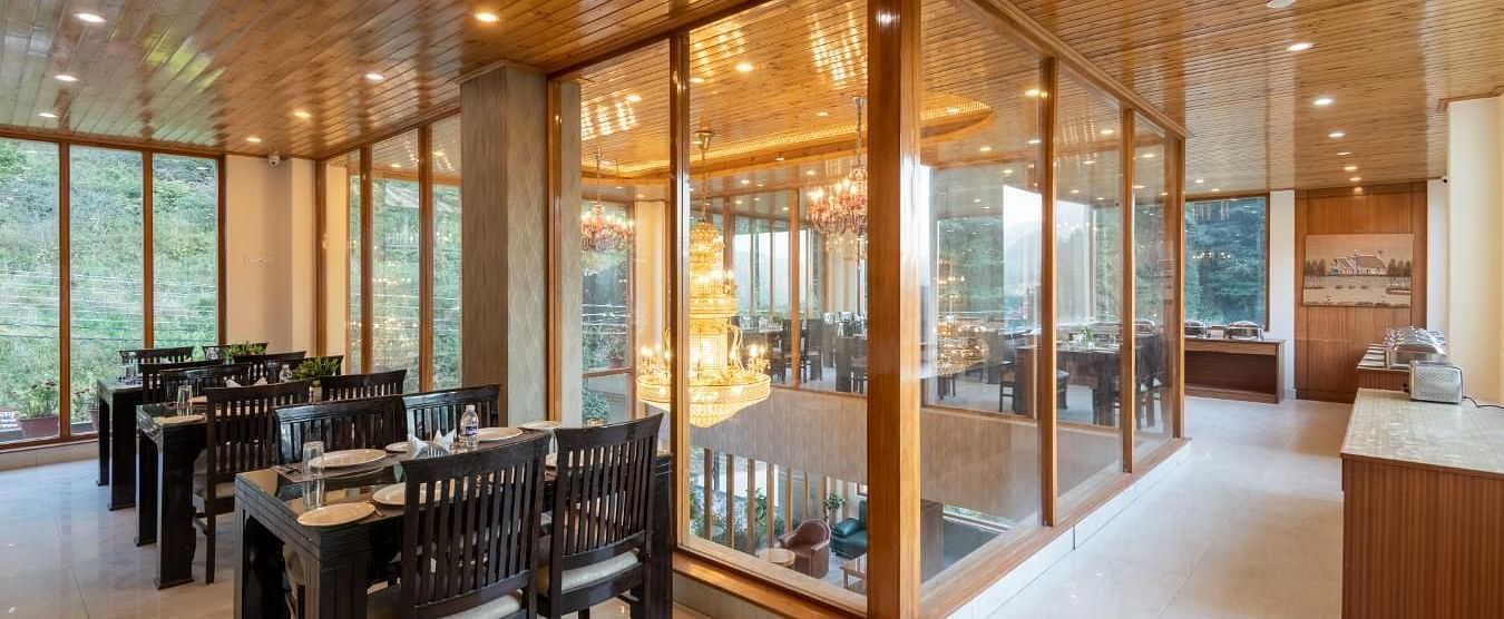 Image of a  spacious restaurant with large windows overlooking a scenic view  | DLS Serenity Resort and Spa