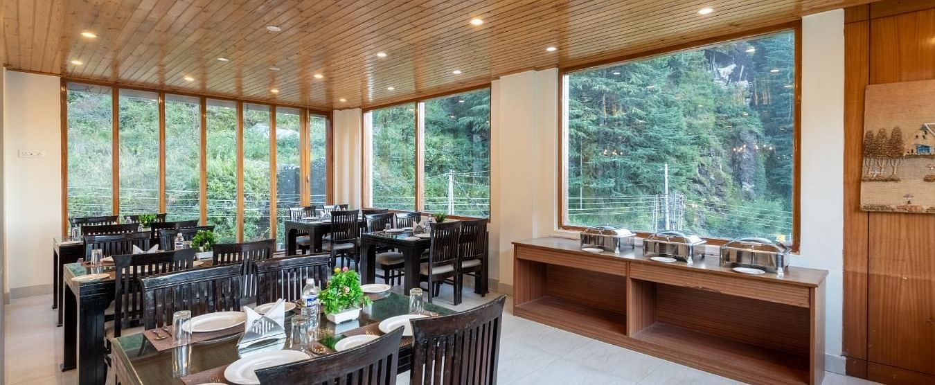 Image of a  spacious restaurant with large windows overlooking a scenic view  | DLS Serenity Resort and Spa