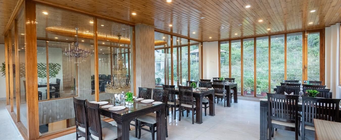 Image of a seating arrangements with tables and chairs, likely designed for both casual and formal dining  | DLS Serenity Resort and Spa