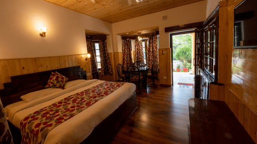Side view of the family room with a cosy king-sized bed at The Pavilion, Nainital