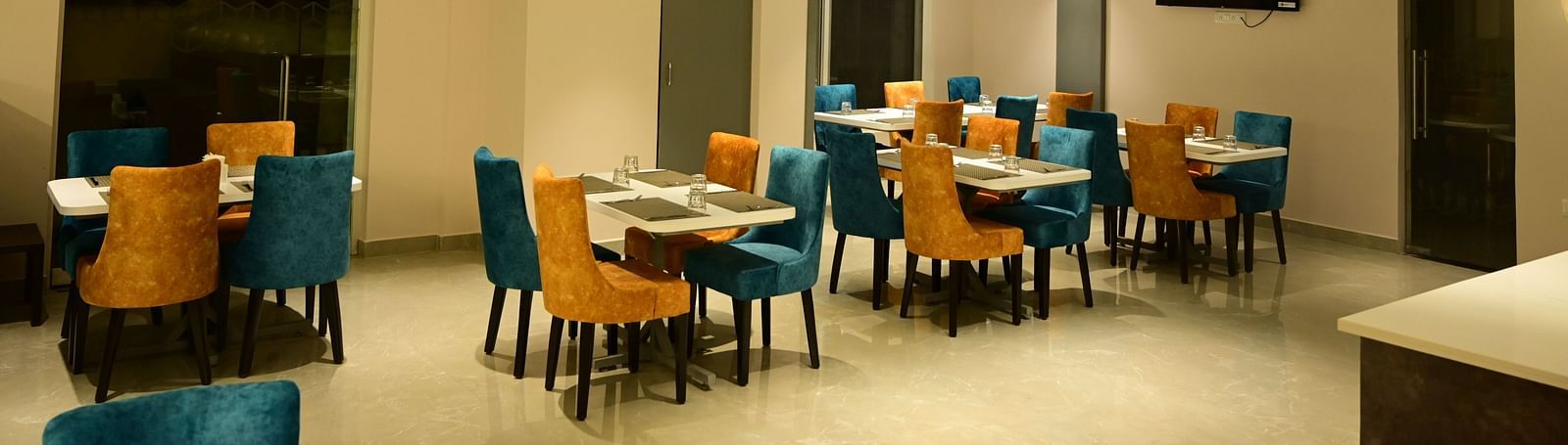 Blue and Yellow coloured chairs at the restaurant at Sterling Keys by TGI in Bnagalore