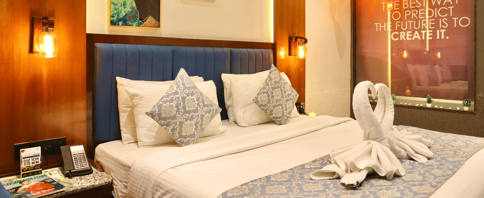 Classic Room, Bed framed by wall sconces and artwork