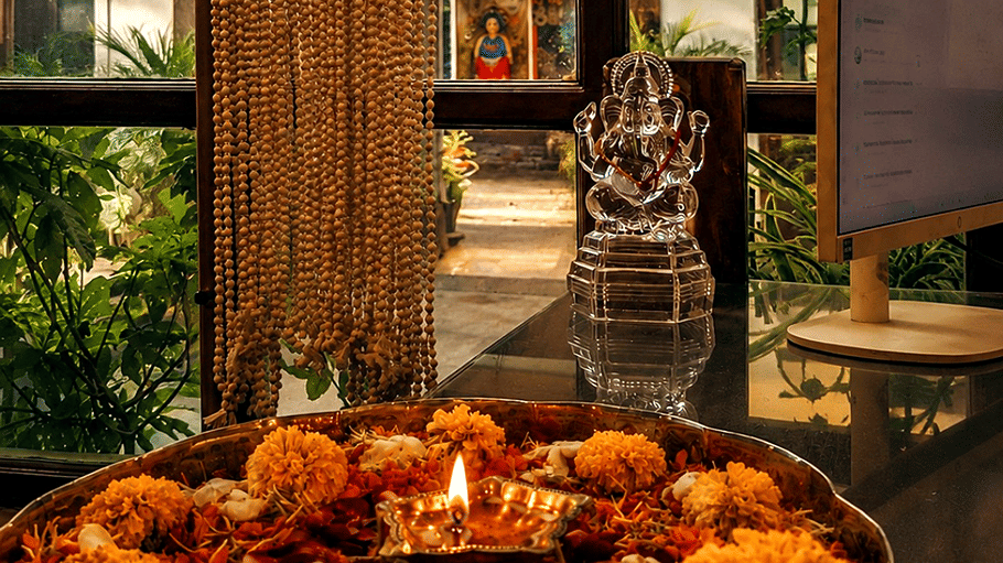 Flowers offered to a god's idol with a diya infront of it. | Hotel Devnadi, Haridwara