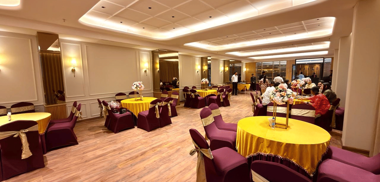 A banquet hall with round tables, neutral decor and soft lighting at Arnisa A Boutique Hotel