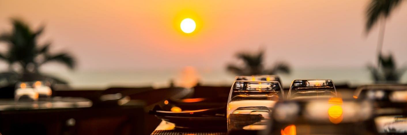 sunset view can be enjoyed from a restaurant open dining area with empty tables - Stone Wood Hotels & Resorts