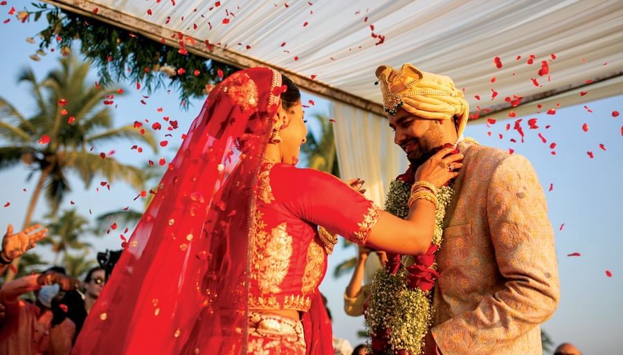 a bride making the groom wear a garland - Caravela Beach Resort Goa