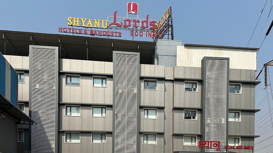 The facade of 'Shyanu Lords Eco Inn Airoli' with the signboard attached on the roof under the blue sky.