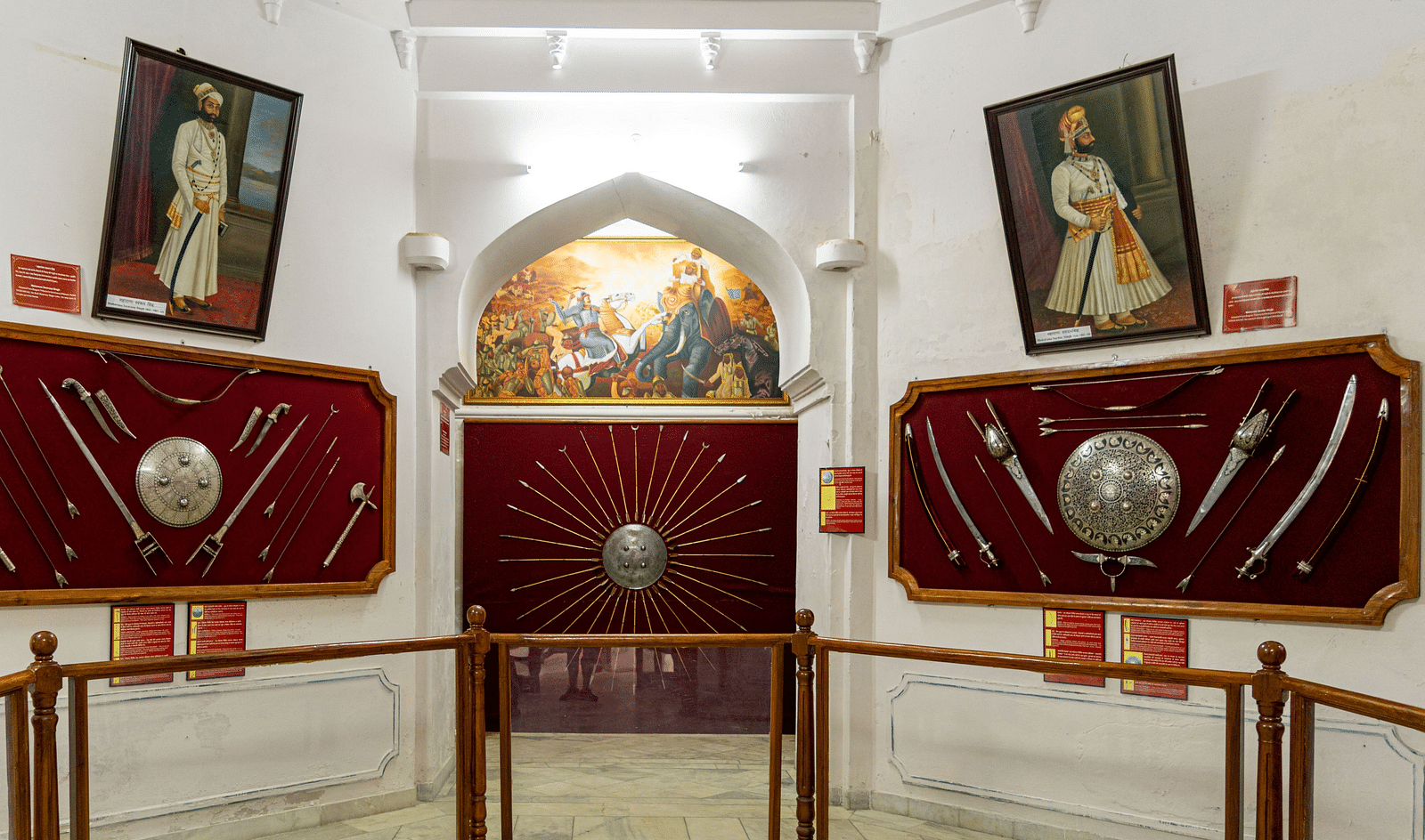An interior shot of a room with framed portraits and displays of swords.