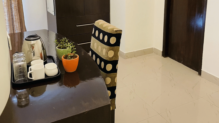 Clean guest room entrance with wardrobe and tiled flooring at Sanctum Suites Domlur Bangalore