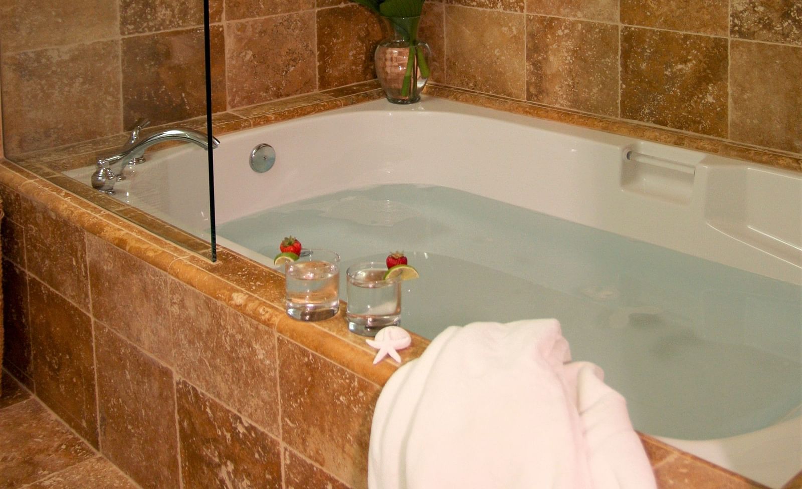 A bathroom featuring a soaking tub and rustic tiles - Brewery Gulch Inn & Spa