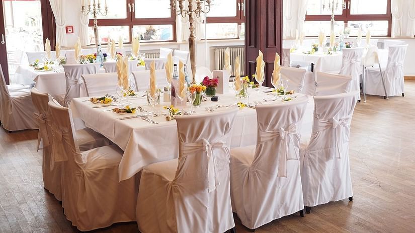 View of Ballroom with tables covered in white linens and several chairs - Mastiff Grand- The Sia Palace Suites and Banquets, Khopoli