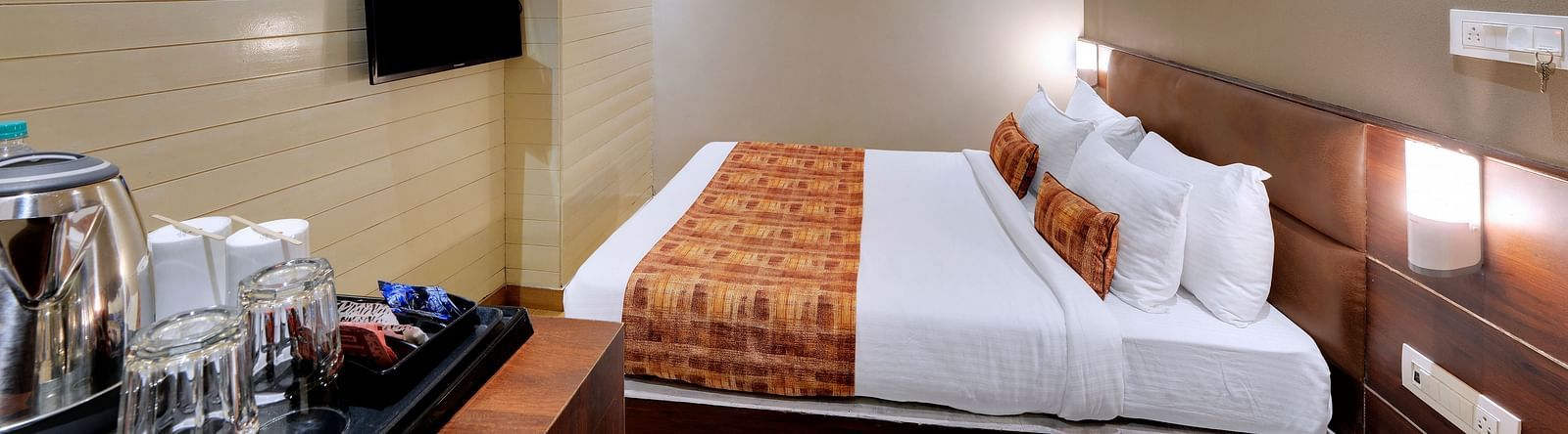 An image of a room with a queen size bed, TV and room amenities like tea coffee maker - Sumitel Vista TV Tower