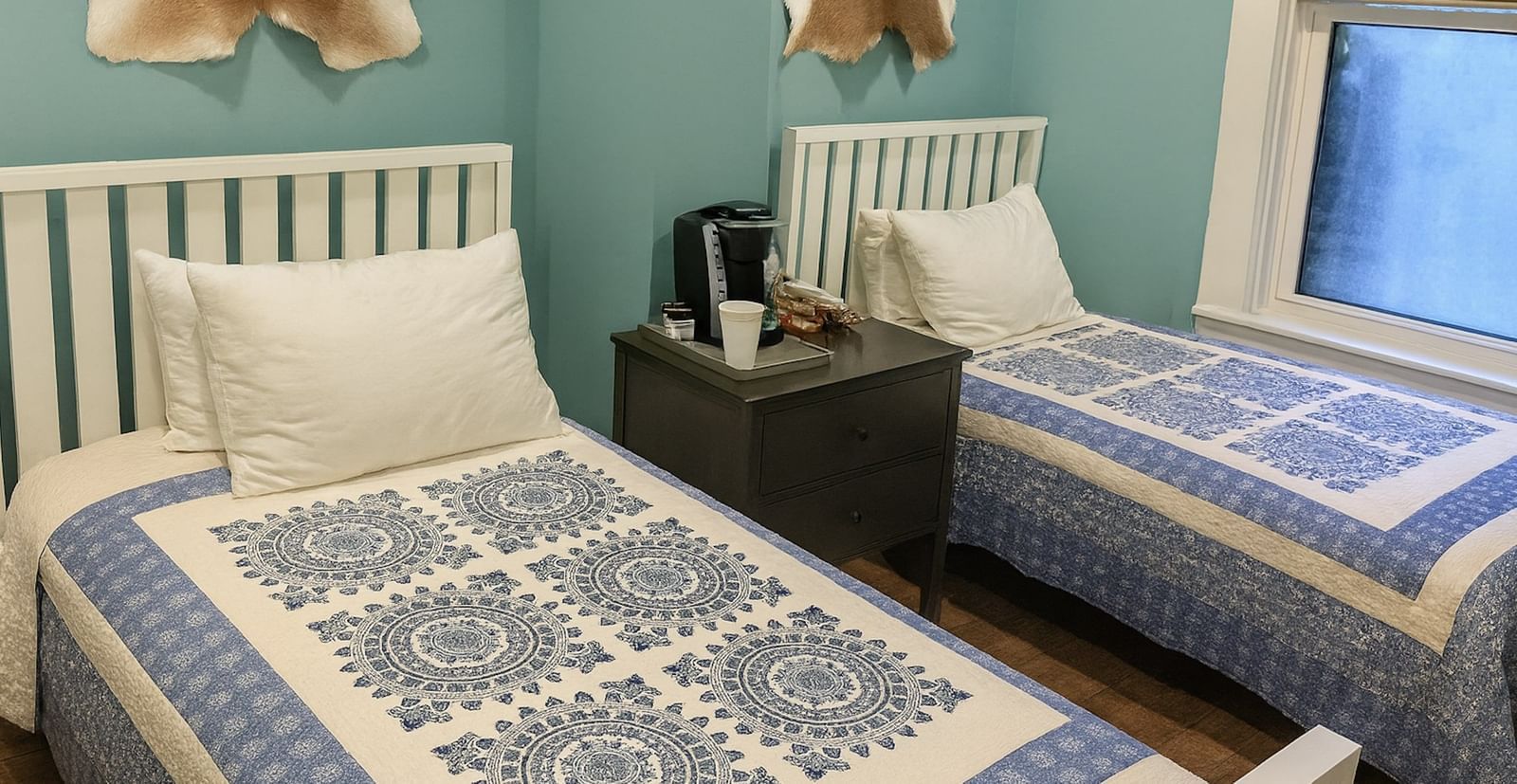 Deluxe Twin room at The Groverland Hotel, furnished with twin beds, a bedside table, and wooden flooring.