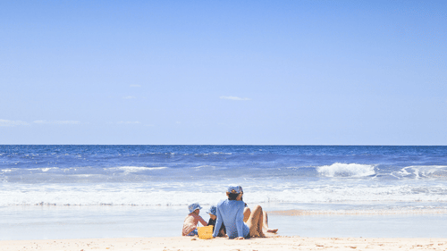 a family sitting on the beach