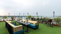  An outdoor dining setup on a rooftop garden overlooking a bridge and river during daylight - Polo Floatel