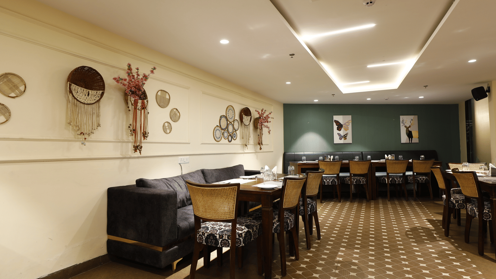 Elegant dining space of The Papaya Kitchen, Papaya Tree Hotels, adorned with ethnic wall decor and cosy seating, offering a warm and inviting ambience.