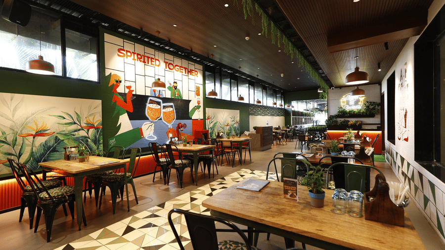 A Vibrant cafe at Papaya Tree Hotels with artistic wall murals, wooden tables, and a cosy ambience for casual dining.