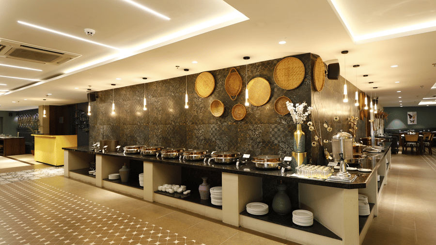 Buffet dining area at The Papaya Kitchen,  Papaya Tree Hotels, with an elegant serving counter and modern interior designed for fine dining experiences.