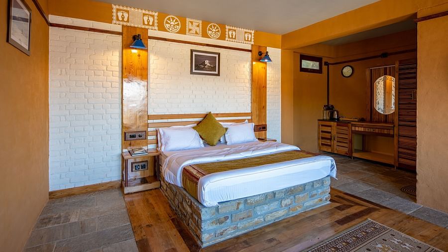 Rustic bedroom with a wooden bed, white brick wall, and traditional decor accents. - Blusalzz Homes The Himalayan Bungalow, Almora