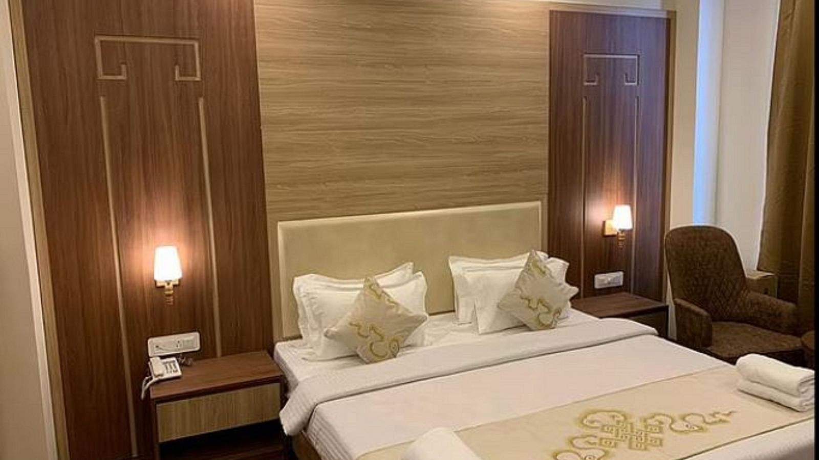 Overview of the Deluxe Room with a queen bed, side tables and lamps - Sumitel Gangtok