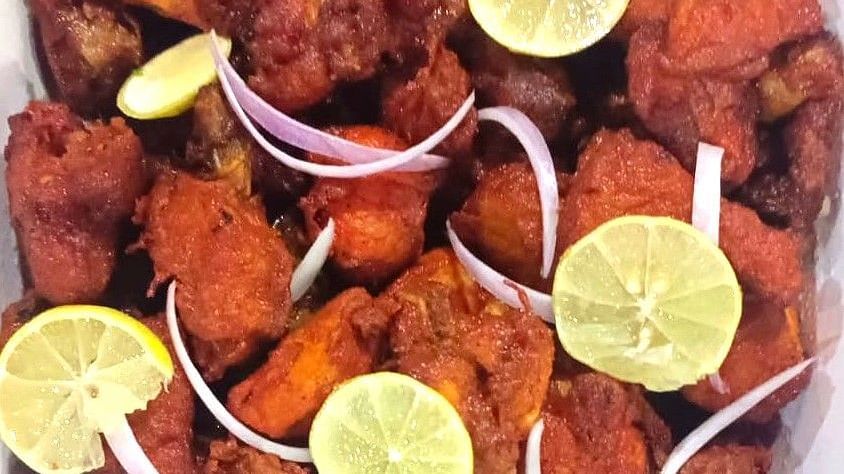Image of crispy chicken 65 garnished with slices of lemon and onion at Villa Serenity Le Sejour, Pondicherry.