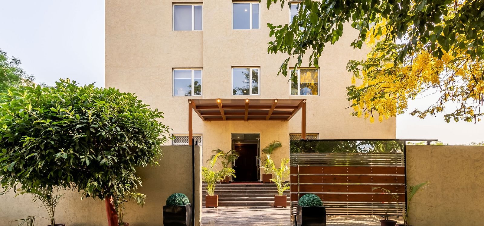 Inde Cyber City porch area entrance surrounded by trees | Inde Hotel Cyber City