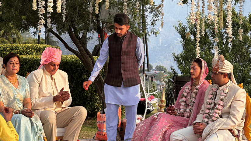 Outdoor wedding ceremony setup with guests seated among tall trees at The Manor Luxury Apartments, Shimla.