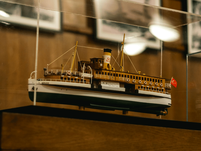 A scale model ship enclosed in glass displayed in a museum. 