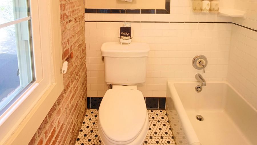 a close up image of the commode in a bathroom with a bathtub besides it - Historic Tapoco Lodge