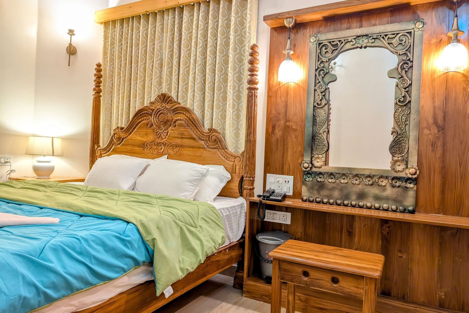 A corner view of a  double bed at the pool side cottage at dip holidays along with a dressing table besides it
