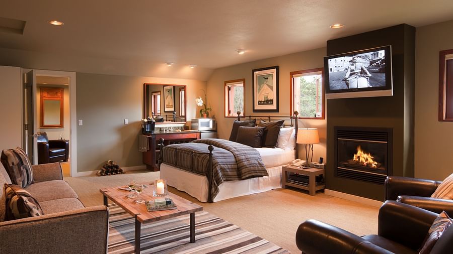Meadowview Suite featuring a couch, a teapoy, a plush bed, a wall-mounted television and a leather couch - Brewery Gulch Inn & Spa