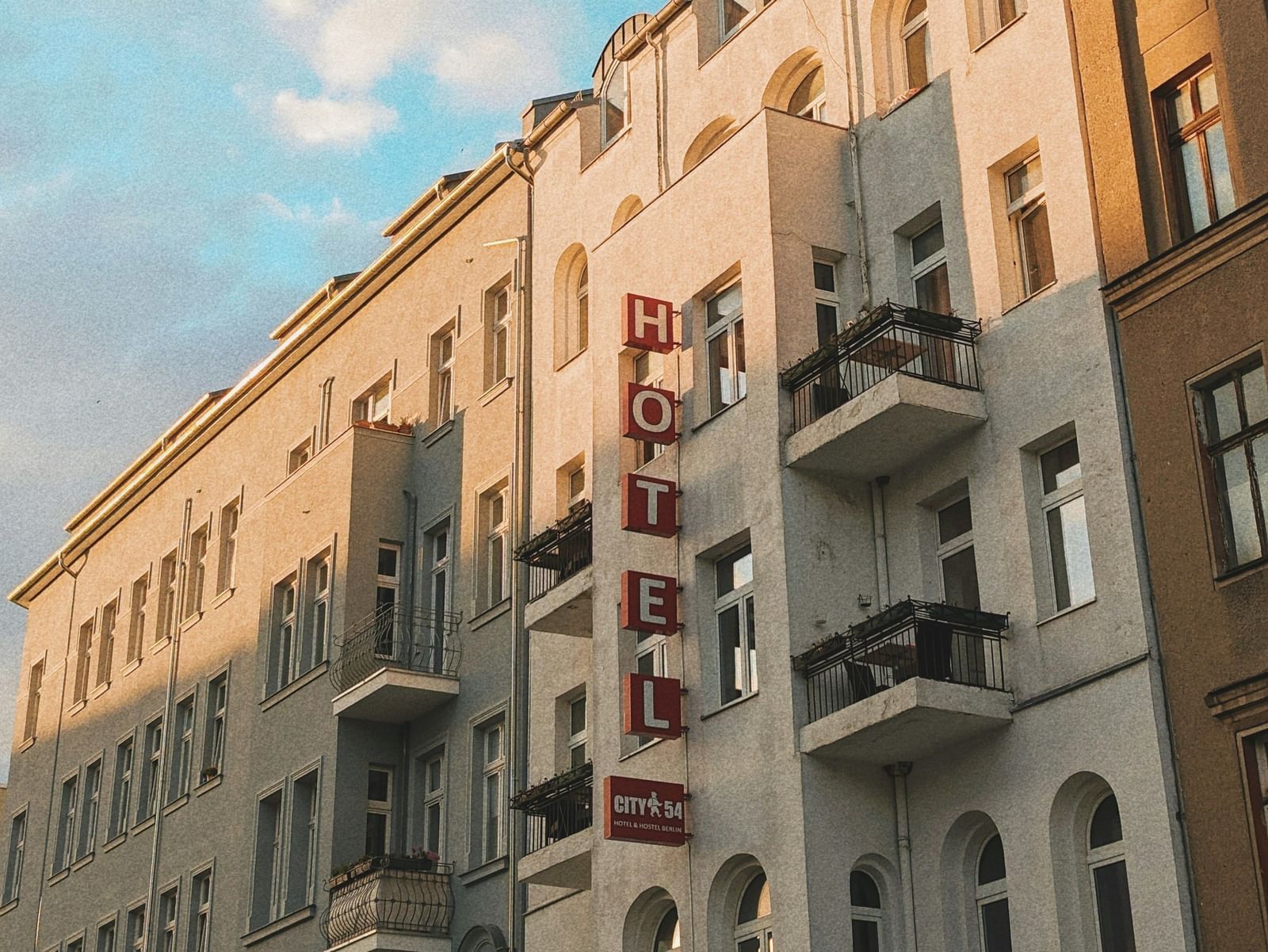  A low-angle view of a row of European-style buildings with balconies under a blue sky