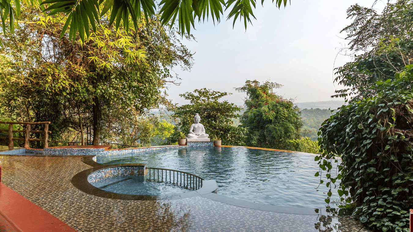 A swimming pool with a white statue at the edge, surrounded by trees.
