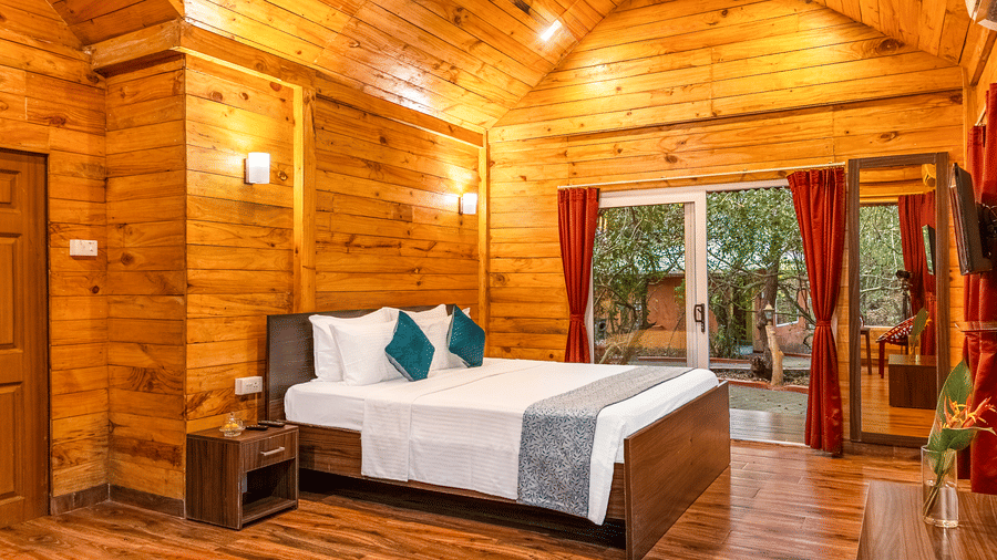 Inside a wooden cabin bedroom with warm yellow lighting.