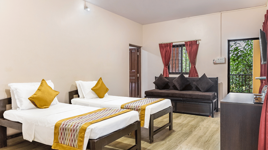 A bright bedroom with two single beds and white bedding.