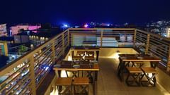 Image of Sky Deck rooftop restaurant featuring tables and chairs placed under the night sky