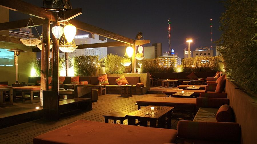 A rooftop restaurant featuring a bunch of tables and chairs