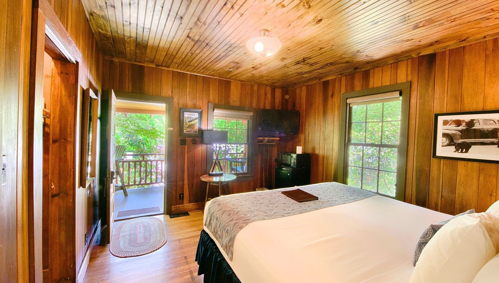 a beautiful image of a bedroom with wooden interiors with a double bed in the middle of the room - Historic Tapoco Lodge